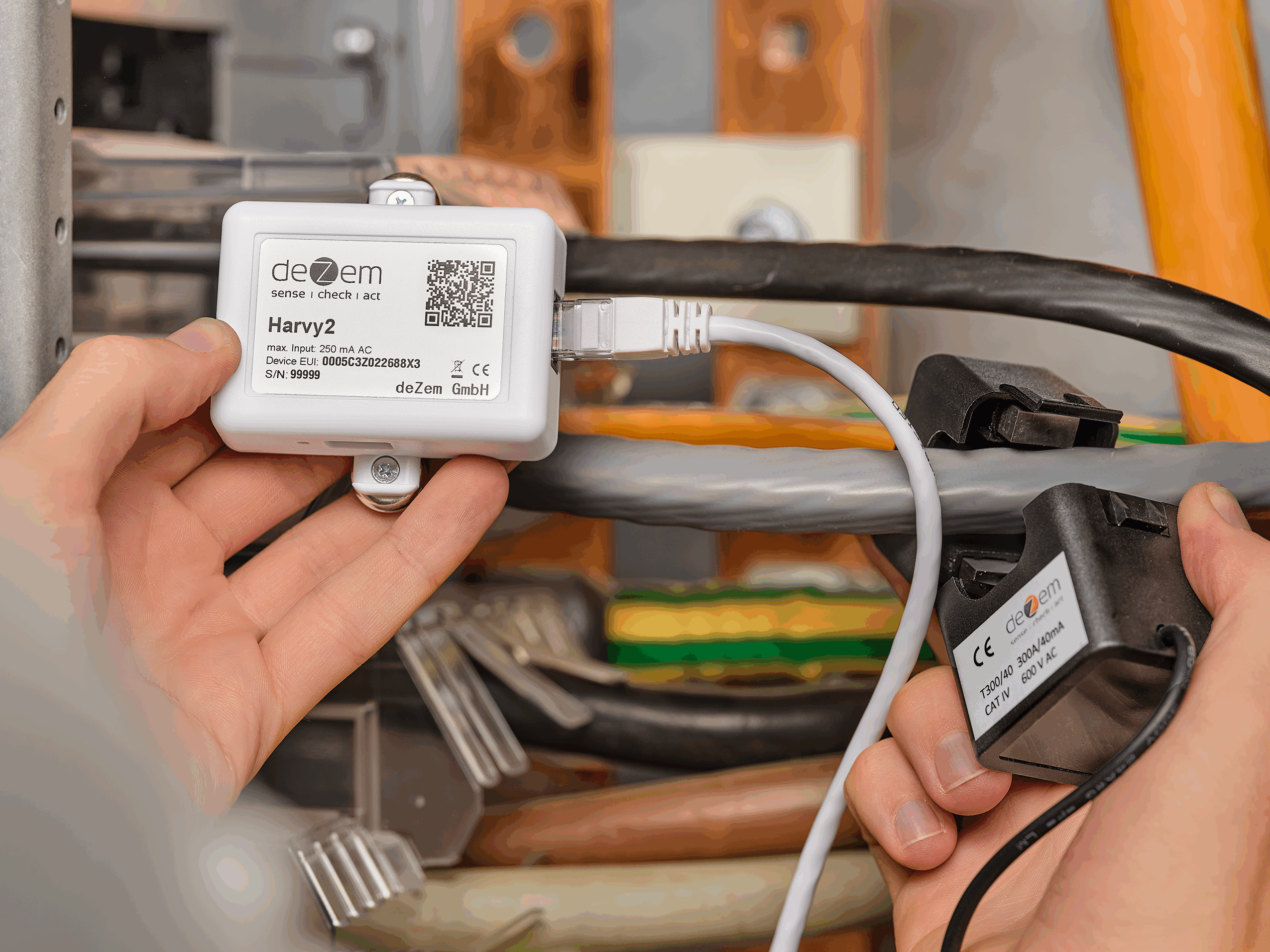 Der batteriefreie Harvy2 LoRaWAN-Stromsensor und die passenden Klappstromwandler werden zur Effektivstrommessung an einer Lüftungsanlage installiert.